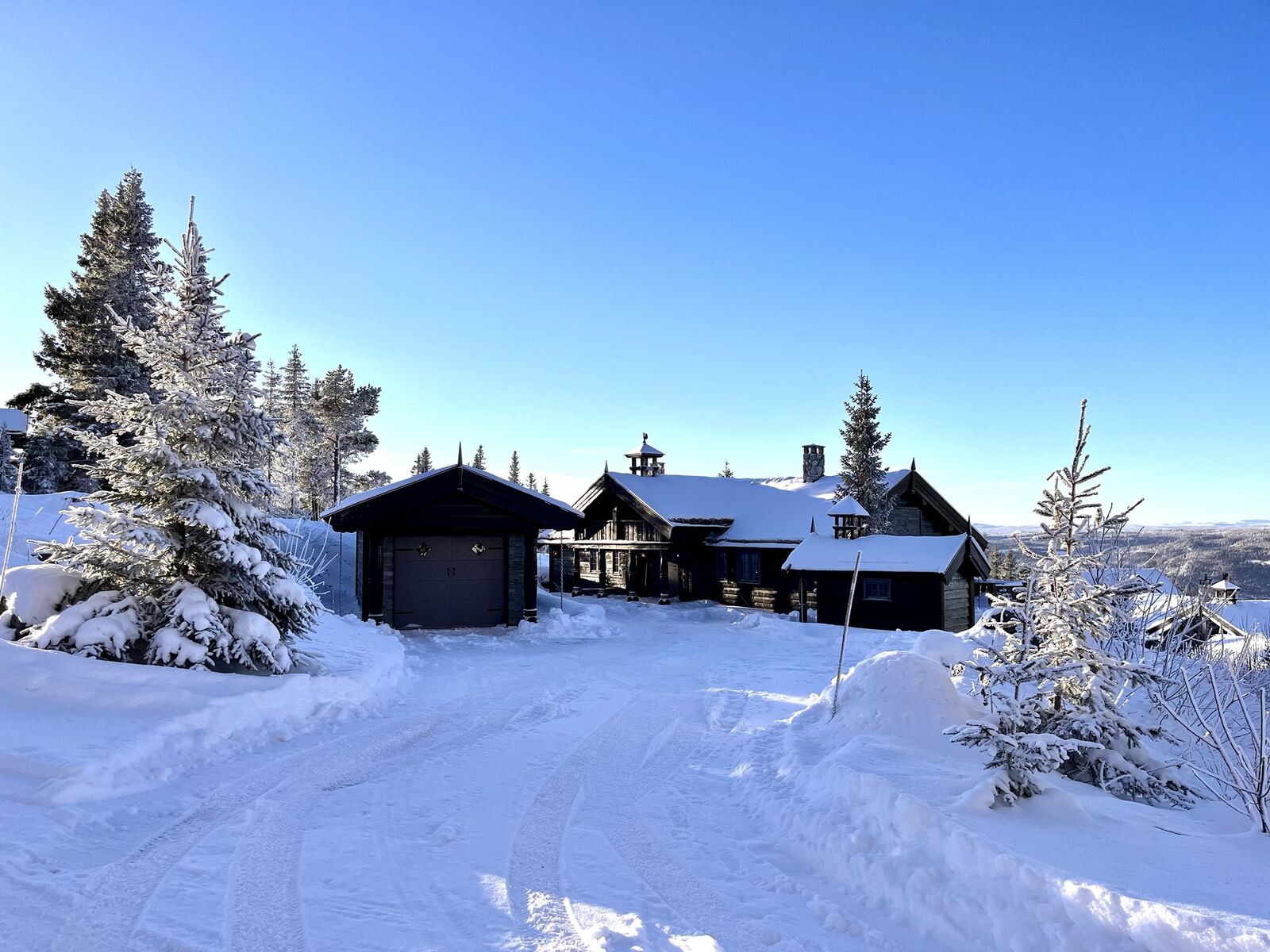Tunet med garasje og hytta en klar vinterdag